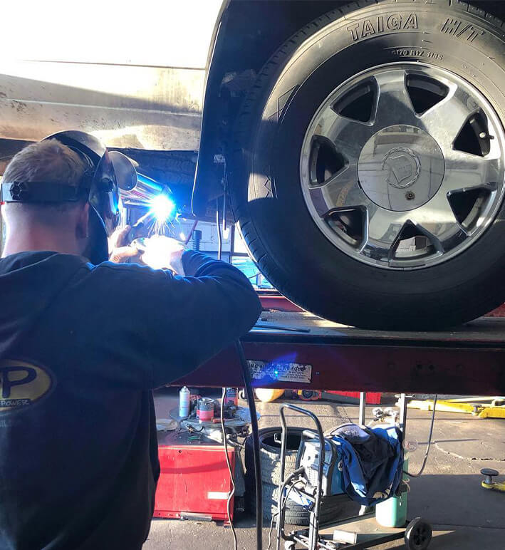 Auto Repair Tech working on a car with a Taiga H/T Tire