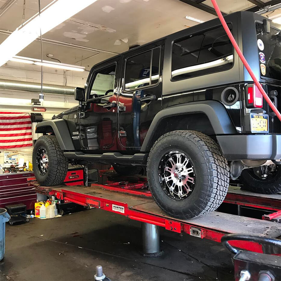 Jeep lifted in a Mechanic shop for a repair